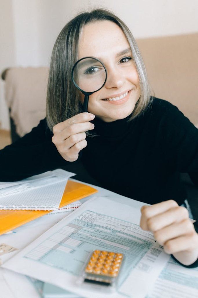 A Woman in Black Long Sleeve Shirt Holding a Magnifying Glass