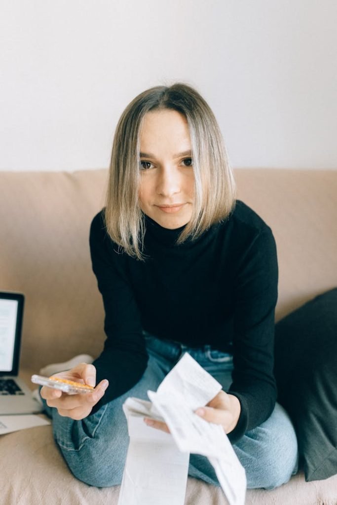 A Woman in Black Long Sleeve Shirt Sitting on Brown Sofa