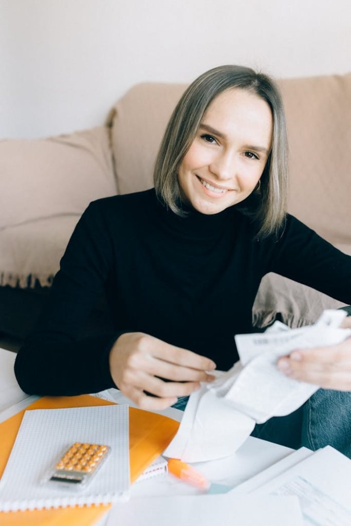 Woman in Black Long Sleeve Shirt Holding White Printer Paper